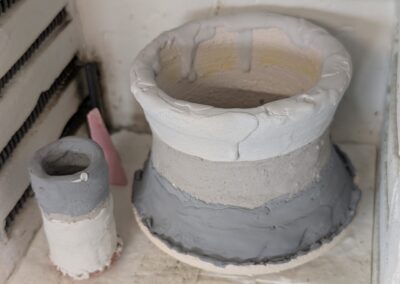 Handgemachte Keramikbecher und Kurinuki-Schalen vor dem finalen Brand im Schweizer Atelier.